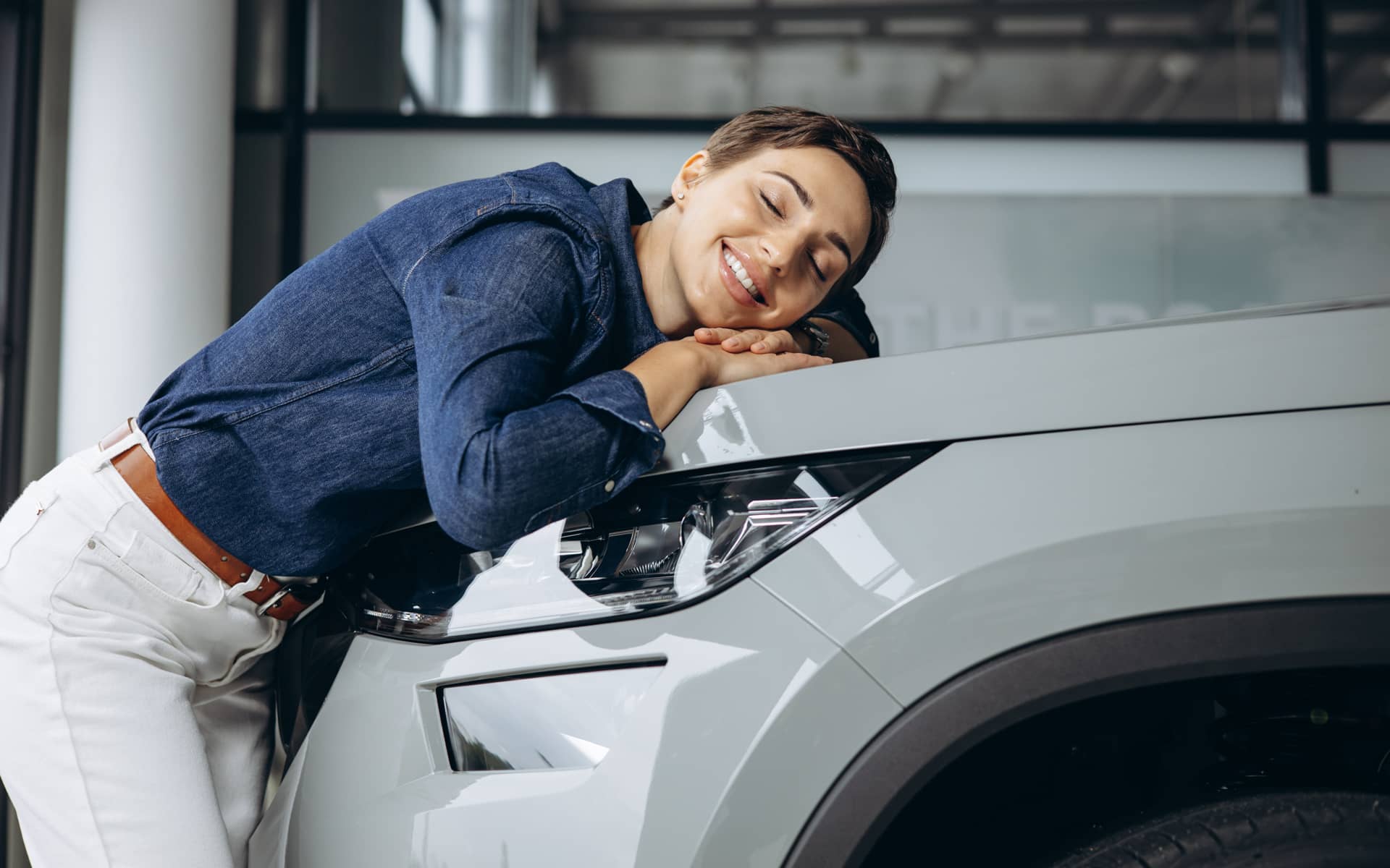 Frau lehnt an Motorhaube
